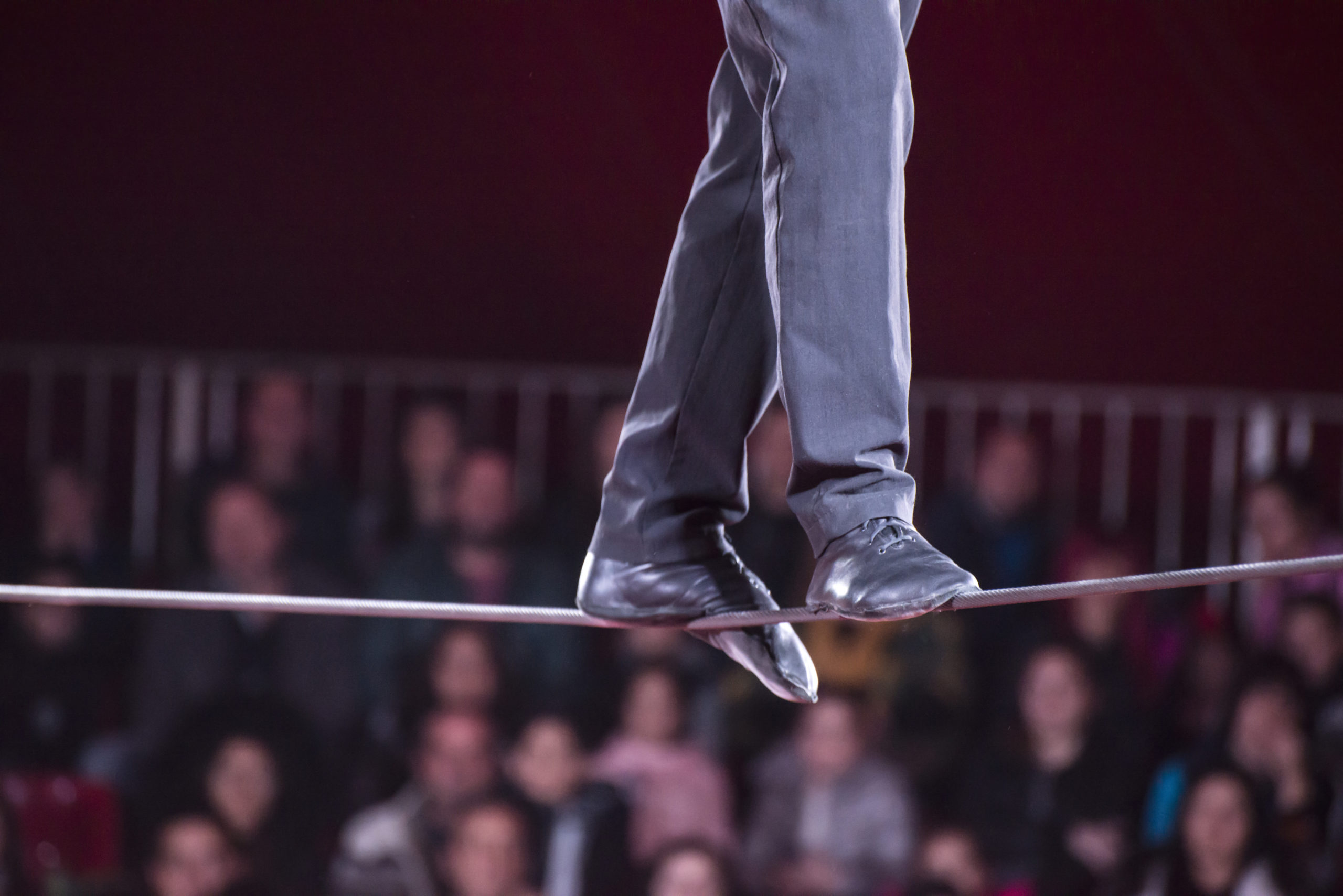 A man walks on a tight wire in circus.